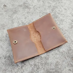 Opened view of a vintage brown crazy horse leather card holder with dual slots.