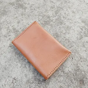 Close-up of handmade vintage brown crazy horse leather card holder on concrete