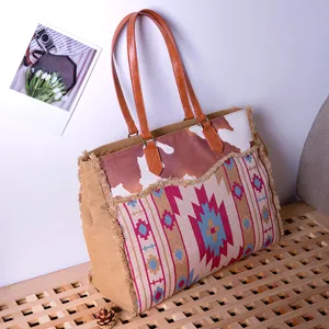 Bohemian canvas tote bag with Aztec patterns and fringe detailing shown in a cozy room