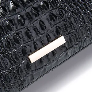 Detalle de cerca del patrón de cocodrilo negro brillante en bolso retro de mujer