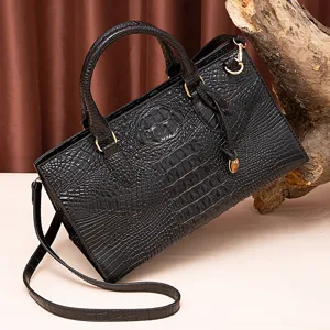 Elegante bolso de mano de piel negra con grabado de cocodrilo, herrajes dorados y correa