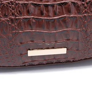 Macro dettaglio della ricca trama a coccodrillo marrone su una borsa sottobraccio in stile vintage