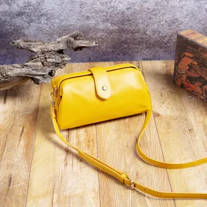 Bolso de médico vintage de cuero PU amarillo con cierre de beso sobre fondo de madera rústica