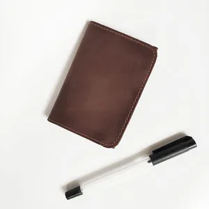 Vintage brown crazy horse leather card holder wallet shown next to a black pen for scale.
