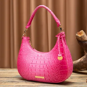 Dettaglio di una borsa hobo retrò rosa con trama a coccodrillo goffrata e finiture dorate