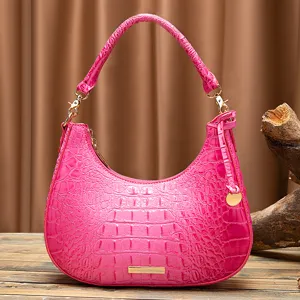 Primo piano di una borsa sottobraccio retrò rosa con trama a coccodrillo in rilievo