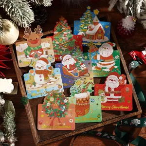 Set handgezeichneter Weihnachtskarten mit Goldfolie auf einem hölzernen Tablett.