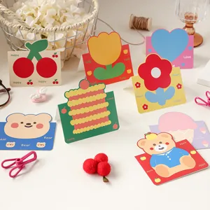 Primer plano de coloridas tarjetas de felicitación plegables con varios motivos de animales y frutas