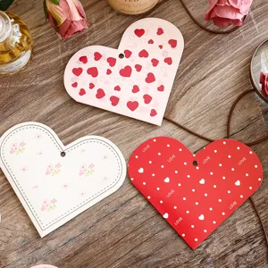 Nahaufnahme von herzförmigen Geschenkanhängern mit Blumen-, Punkte- und Herzmustern.