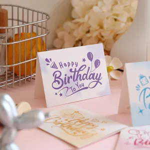 Close-up detail of Happy Birthday greeting card with purple artistic typography on paper