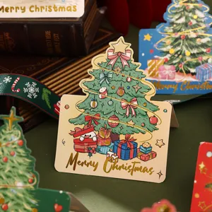 Detailed view of a gold-foiled Christmas tree greeting card with festive gift box illustrations.