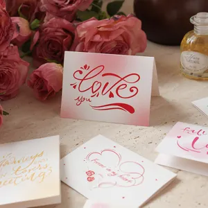 Detalle de elegantes tarjetas de felicitación con caligrafía roja Love You y rosas rosas