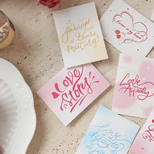 Detalle de tarjetas de felicitación estéticas con citas de amor y textura artística.