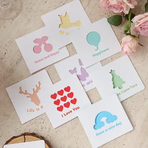 Varietà di biglietti d'auguri minimalisti con vari vivaci disegni ritagliati colorati