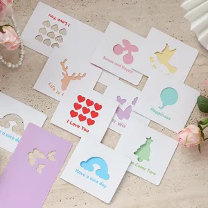 Una collezione di biglietti d'auguri quadrati traforati con vari motivi colorati