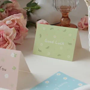 Close-up of minimalist green greeting card with floral patterns and Good Luck text