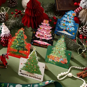 Detailed shot of various gold-foil Christmas tree greeting cards with festive decorations