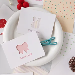 Dettaglio di biglietti di auguri traforati con design a coniglio e fiocco.