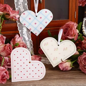 Nahaufnahme von herzförmigen Geschenkanhängern mit Blumen- und Karomustern zum Valentinstag