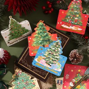 Close-up of gold foil Christmas tree cards on a vintage book