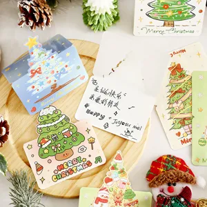 Selection of cute cartoon Christmas greeting cards displayed on a wooden tray