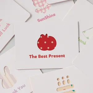 Primo piano di biglietti d'auguri creativi intagliati con testo 'The Best Present' rosso