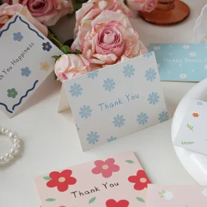 Close-up detail of floral folding greeting cards with Thank You message and pink roses.