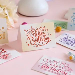 Close-up view of multiple artistic Happy Birthday greeting cards with cartoon doodles