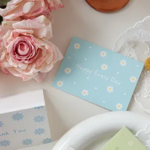 Close-up of light blue floral greeting card with Happy Every Day text and daisy patterns