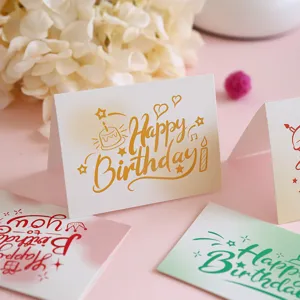 Close-up of artistic birthday greeting card with gold 'Happy Birthday' calligraphy