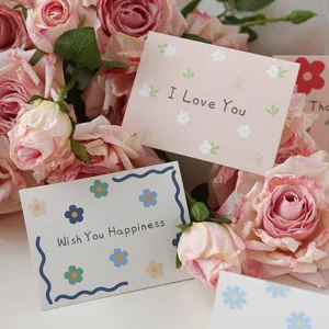 Detailed view of floral greeting cards with 'I Love You' message among pink roses