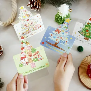 Detailed view of cute hand-held Christmas tree greeting cards for holiday gift messages