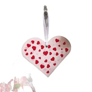 Herzförmiger Geschenkanhänger zum Valentinstag mit roten Mustern und weißem Band.