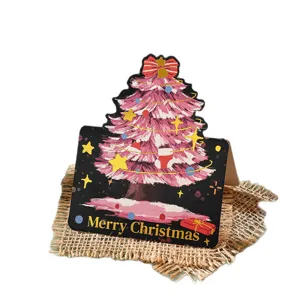 Festive pink Christmas tree shape greeting card with gold foil text on burlap mat