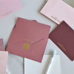 Vista dettagliata di eleganti biglietti di ringraziamento dorati in varie tonalità rosa.