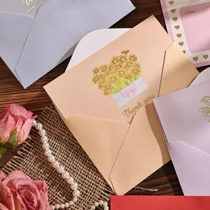 Nahaufnahme einer beige Blumen-Grußkarte mit Goldprägung und bunten Umschlägen