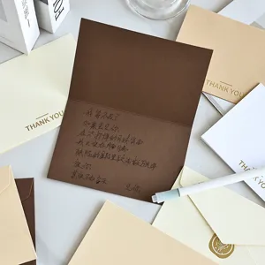 Elegante biglietto di ringraziamento marrone con nota scritta a mano e lamina d'oro di lusso
