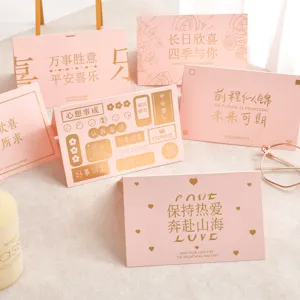 Cartes de vœux roses élégantes avec calligraphie dorée et accessoires déco