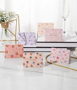 Detailed view of various floral greeting cards with gold foil greetings in a lifestyle setting
