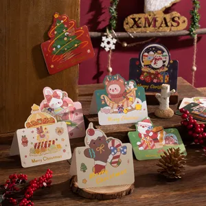 Diverse Christmas gold foil greeting cards with cute cartoon illustrations on wood.