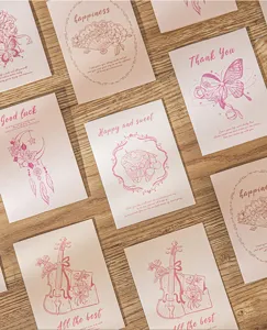 Vintage aesthetic greeting cards with pink floral and butterfly illustrations on wood surface