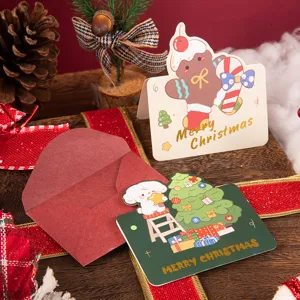 Close-up of festive gold foil Merry Christmas greeting cards with a classic red envelope