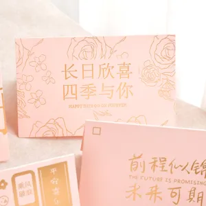Gros plan détaillé de cartes de vœux roses avec texte et fleurs en feuille d'or gaufrée