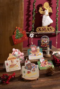 Close-up of various cartoon Christmas greeting cards with elegant gold foil lettering