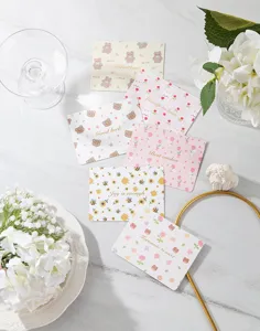 Primer plano de lindas tarjetas de felicitación con animales y flores y letras doradas.