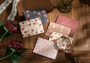 Détail de cartes de vœux florales vintage avec lettrage élégant en feuille d'or sur bois.