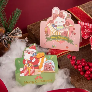 Close-up of bronzing Merry Christmas greeting cards with cartoon Santa and rabbit designs.