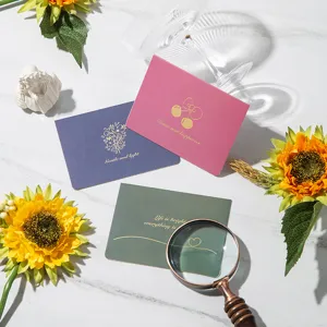 Macro view of elegant gold-stamped greeting cards with floral and cherry design motifs.