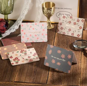 Cartes de vœux florales vintage avec lettrage en feuille d'or sur table en bois