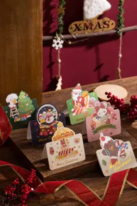 Group of festive Christmas greeting cards with gold foil lettering and cute illustrations